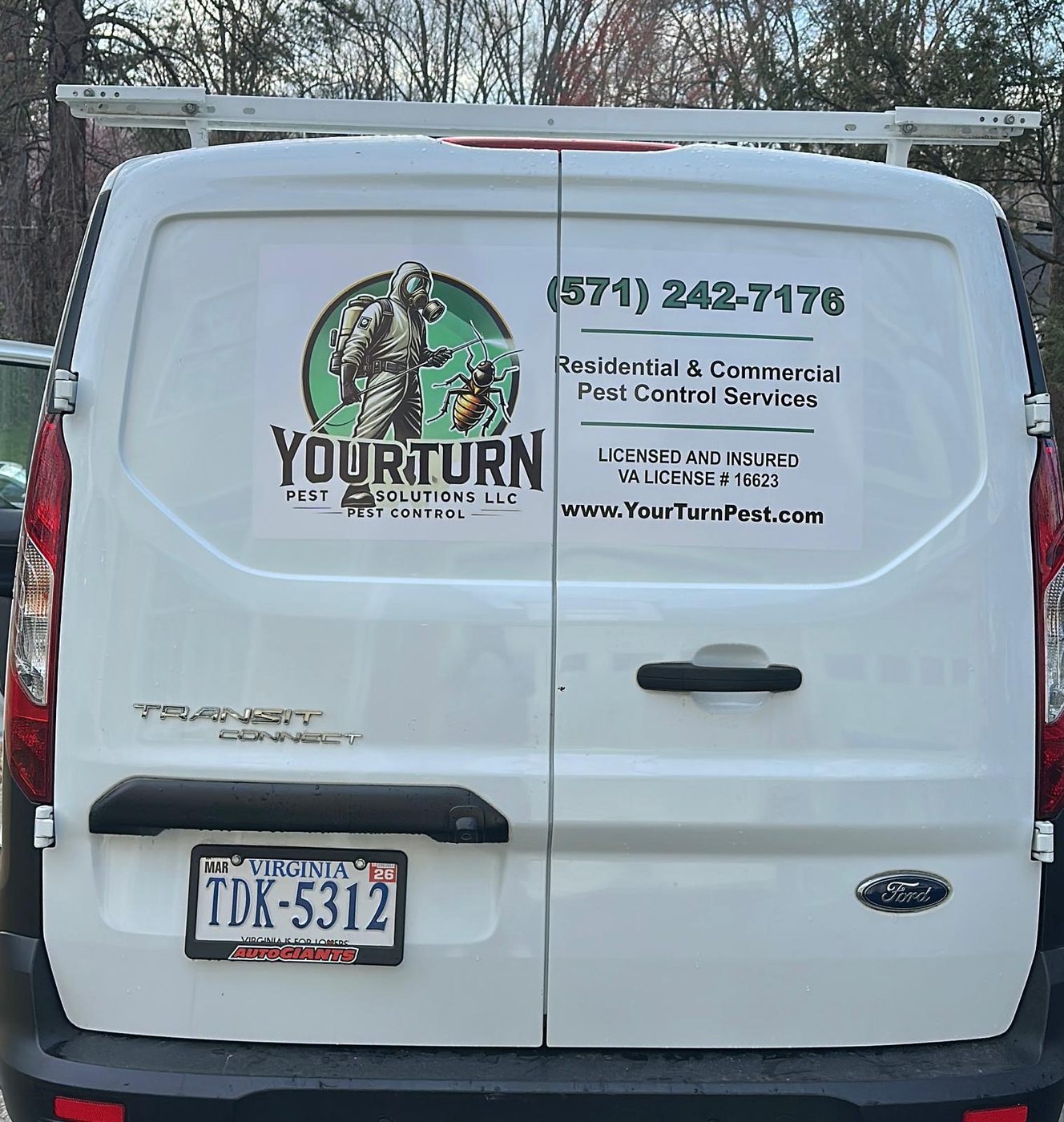 Rear doors of a white YourTurn Pest Solutions LLC service van showing the company logo, phone number, and Virginia license number