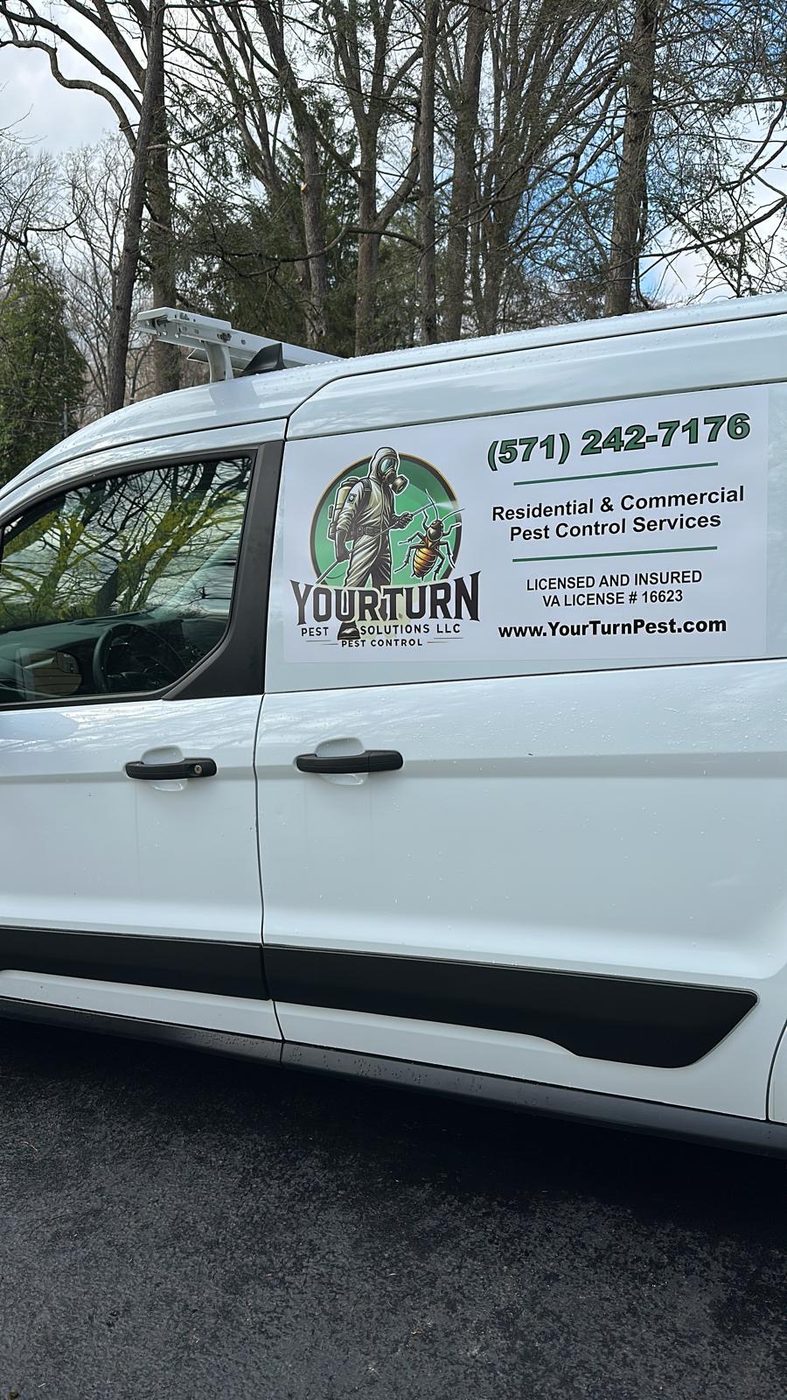 Side door of a white YourTurn Pest Solutions LLC van showing the company logo, phone number, and license information
